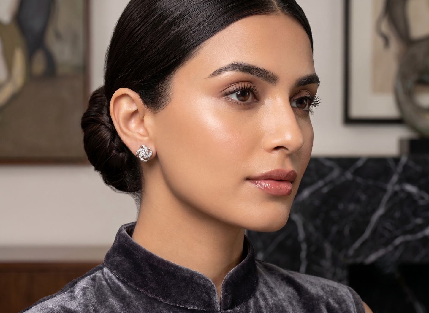 The pair of silver-toned knot stud earrings