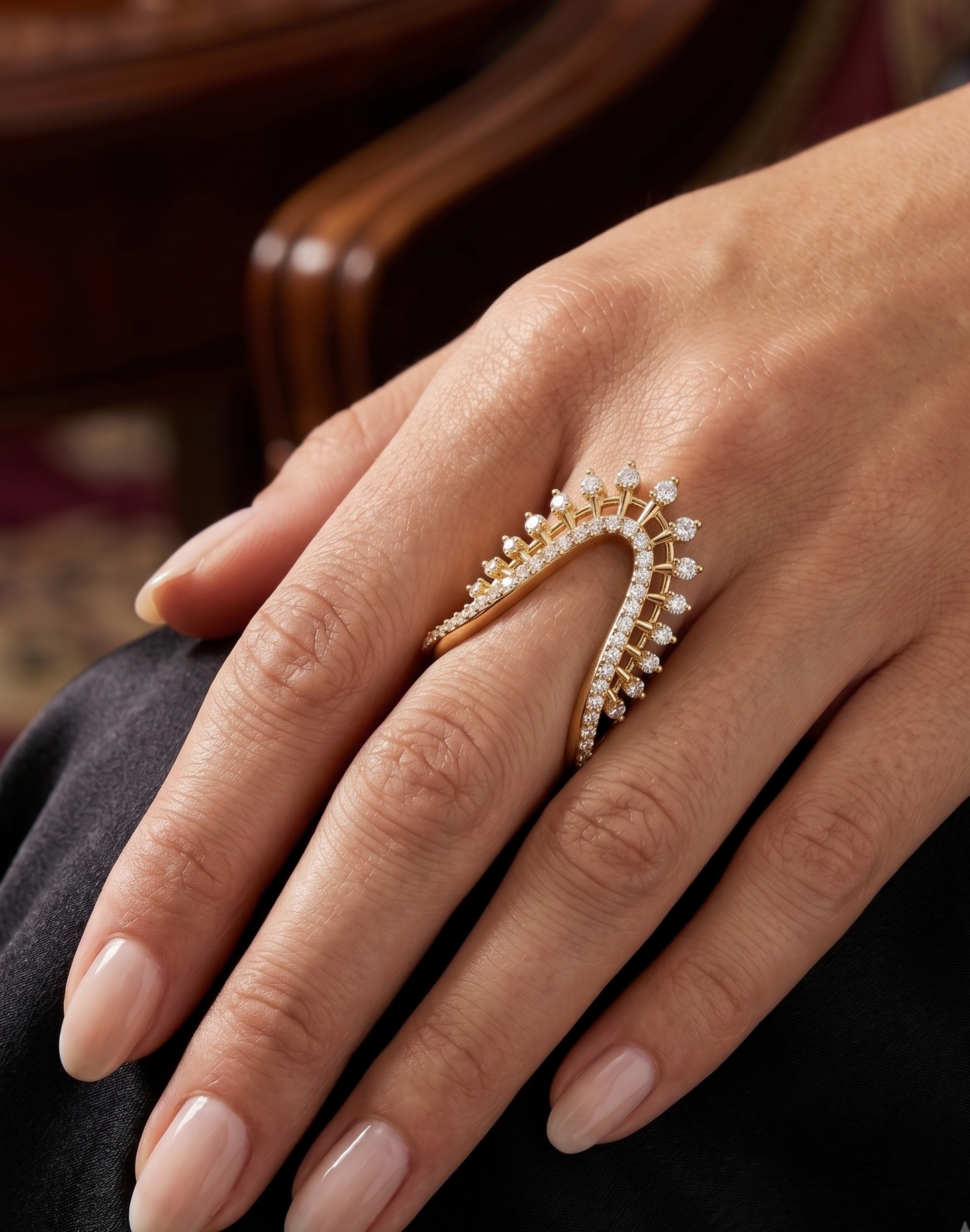 A silver-toned ring featuring a sweeping, open triangular design