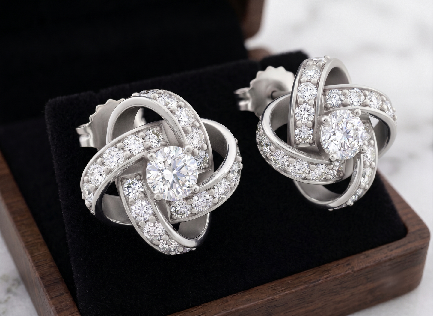 The pair of silver-toned knot stud earrings