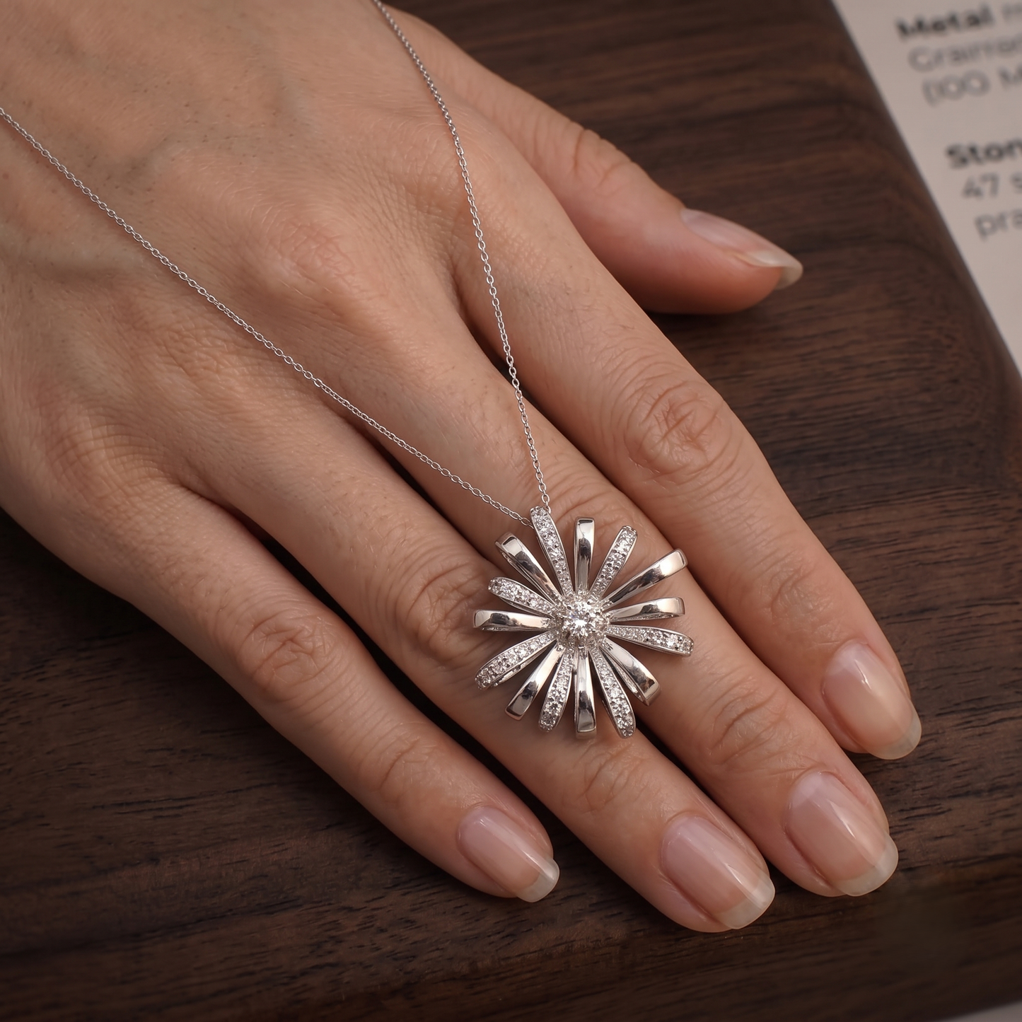A silver sunburst chain pendant