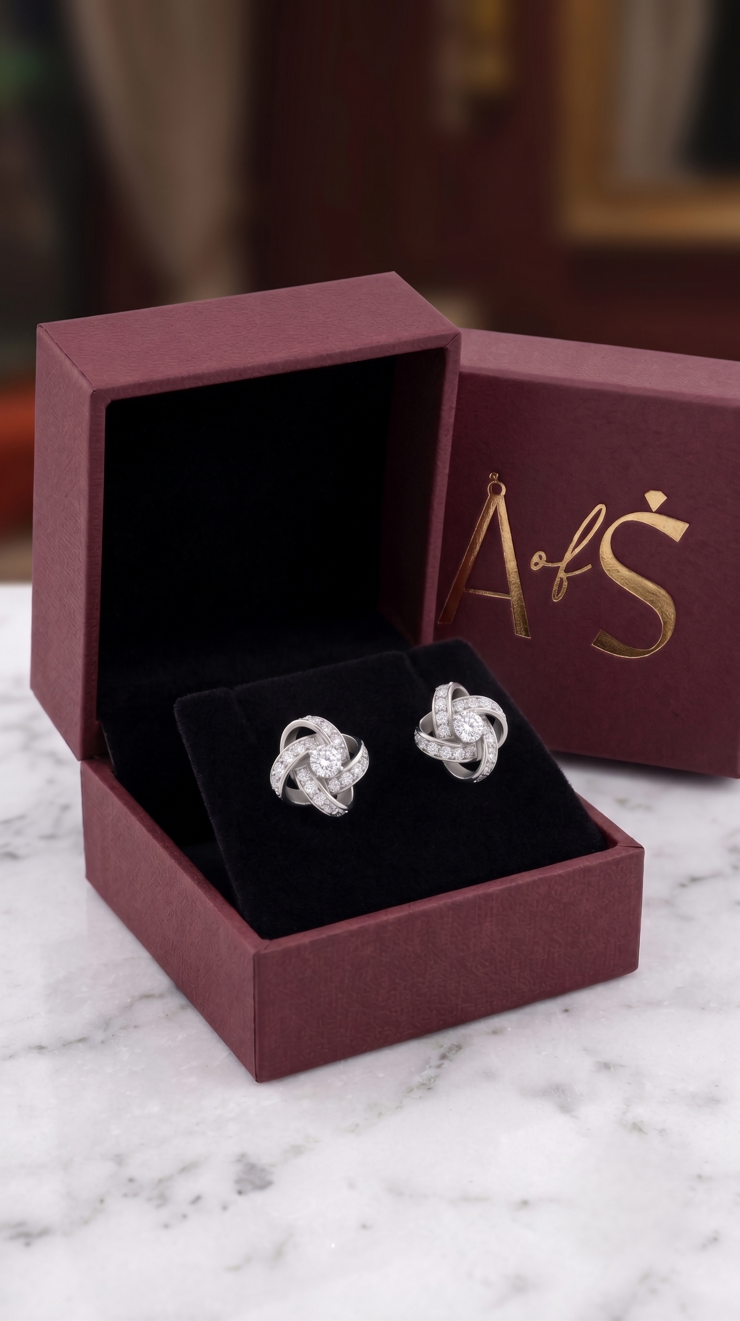 The pair of silver-toned knot stud earrings