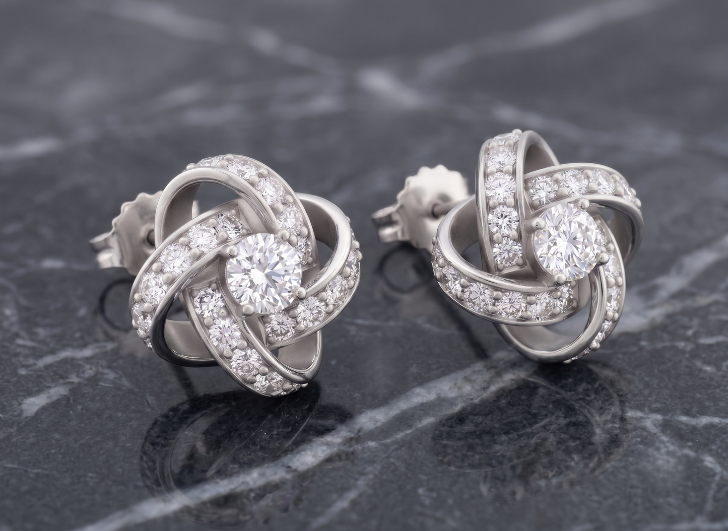 The pair of silver-toned knot stud earrings