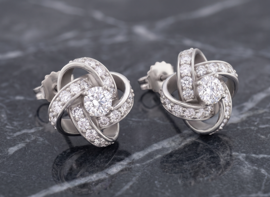 The pair of silver-toned knot stud earrings