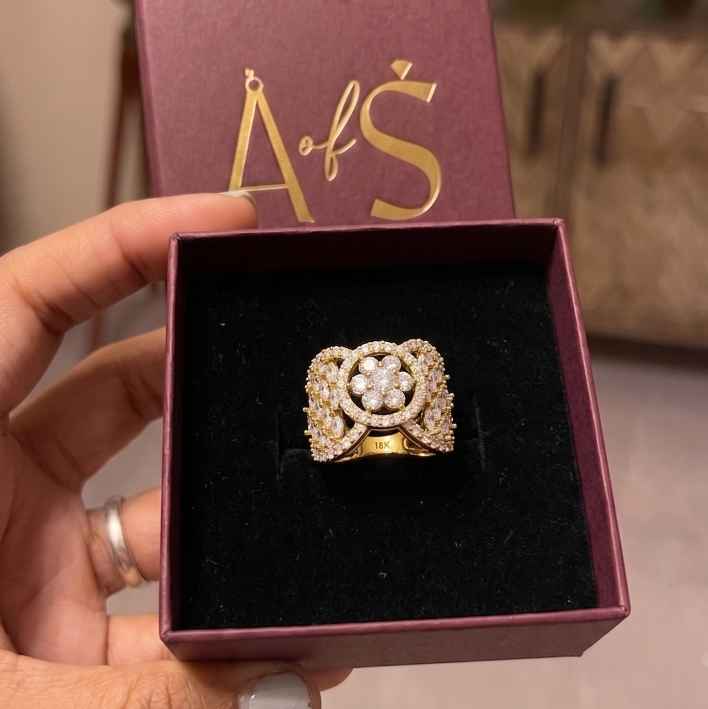 A wide yellow gold plated ring featuring